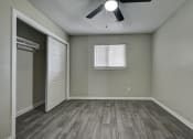 Thumbnail 12 of 20 - an empty bedroom with a closet and a ceiling fan at The Crossings at Montrose Apartments, San Antonio
