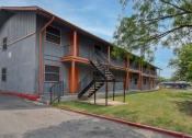 Thumbnail 6 of 20 - the exterior of an apartment building with stairs and a sidewalk at The Crossings at Montrose Apartments, San Antonio, Texas