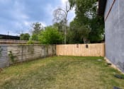 Thumbnail 5 of 20 - a backyard with a wooden fence and a wooden privacy fence at The Crossings at Montrose Apartments, San Antonio, 78223