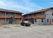 Thumbnail 19 of 20 - a car parked in front of a motel with a building at The Crossings at Montrose Apartments, San Antonio, TX, 78223