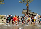 Thumbnail 55 of 57 - A group of people are playing in a water fountain at Civita Park at Purl Apartments, San Diego