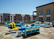 Thumbnail 8 of 57 - A sunny day at a modern outdoor seating area with blue and yellow chairs at Purl Apartments, California