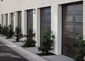 Thumbnail 8 of 26 - a row of garage doors and a sidewalk at Luma at El Corazon Apartments, Oceanside, California