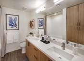 Thumbnail 22 of 26 - a bathroom with two sinks and a toilet at Luma at El Corazon Apartments, Oceanside, CA