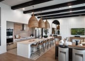 Thumbnail 16 of 26 - a large kitchen with a large island and bar with stools at Luma at El Corazon Apartments, Oceanside, 92056