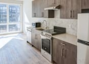 Thumbnail 18 of 19 - A kitchen with a stove top oven and a microwave.
