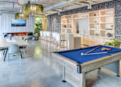 Thumbnail 6 of 19 - A pool table in a room with a blue cloth and white cues.