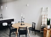 Thumbnail 5 of 10 - A dining room with a round table and chairs.