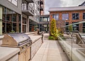 Thumbnail 50 of 113 - an outdoor patio with a grill and a building at The Audubon New Haven, New Haven, CT, 06511