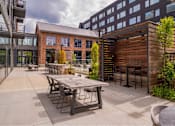 Thumbnail 54 of 113 - a patio with a table and chairs outside of a building at The Audubon New Haven, New Haven, CT, 06511
