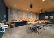 Thumbnail 41 of 113 - a dining room with tables and chairs and a wall with magnets on it at The Audubon New Haven, New Haven, CT, 06511