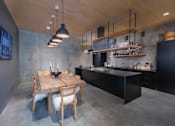 Thumbnail 43 of 113 - a kitchen with a wooden table and black cabinets at The Audubon New Haven, New Haven