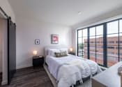 Thumbnail 35 of 113 - a bedroom with a bed and a large window at The Audubon New Haven, New Haven, CT, 06511