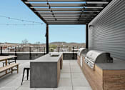 Thumbnail 12 of 113 - the deck has an outdoor kitchen with a grill and a table at The Audubon New Haven, New Haven