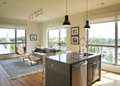 Thumbnail 99 of 113 - the living room and kitchen of an apartment with a view of the city at The Audubon New Haven, New Haven, CT