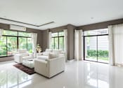Thumbnail 2 of 4 - A living room with a white sofa set and a brown rug.