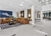 Thumbnail 10 of 24 - A modern living room with a large couch and a painting on the wall.