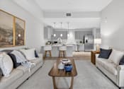 Thumbnail 3 of 24 - A modern living room with a grey sofa and a coffee table.