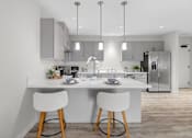 Thumbnail 2 of 24 - A modern kitchen with a dining table and chairs.