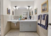 Thumbnail 9 of 24 - A bathroom with a sink, mirror, and towel rack.