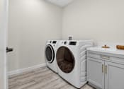Thumbnail 19 of 24 - A washing machine and dryer in a laundry room.