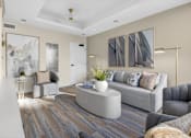 Thumbnail 11 of 24 - A modern living room with a grey sofa and a wooden floor.
