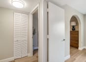 Thumbnail 8 of 38 - a renovated hallway with white closet doors and a door to a bedroom