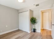 Thumbnail 4 of 38 - an empty living room with a white door and a potted plant