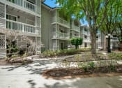 Thumbnail 34 of 38 - exterior view of an apartment building with trees and a sidewalk