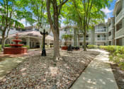 Thumbnail 32 of 38 - a courtyard with trees and a sidewalk in front of an apartment building