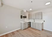 Thumbnail 21 of 25 - A kitchen with a microwave, sink, and cabinets.