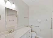 Thumbnail 19 of 25 - A white bathroom with a sink, toilet, and mirror.