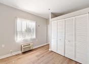 Thumbnail 17 of 25 - A room with a window covered by blinds and a wall-mounted air conditioner.