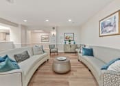 Thumbnail 14 of 25 - A living room with a white couch and a coffee table.