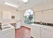 Thumbnail 8 of 25 - A laundry room with a washer and dryer.