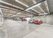 Thumbnail 4 of 25 - A parking garage with three cars parked in it.