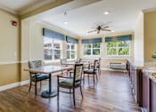 Thumbnail 14 of 19 - A dining room with a table and chairs.