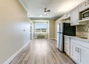 Thumbnail 7 of 19 - A kitchen with white cabinets and a black fridge.