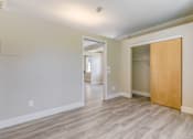 Thumbnail 12 of 19 - A room with a wooden floor and a door on the right side.