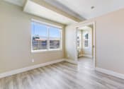 Thumbnail 10 of 19 - A room with a large window and a view of a building across the street.