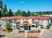 Thumbnail 19 of 19 - A large apartment complex with a parking lot in front.