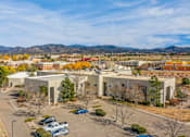 Thumbnail 6 of 10 - A large building with a parking lot in front of it.