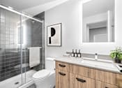 Thumbnail 11 of 12 - Suite 2502 - A modern bathroom with a white toilet, a sink, a mirror, and a shower with a glass door.