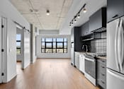 Thumbnail 5 of 5 - A modern kitchen with a large island and stainless steel appliances.