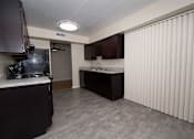 Thumbnail 2 of 33 - A kitchen with dark brown cabinets and a white countertop.