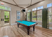 Thumbnail 38 of 40 - a pool table in club house with windows and a tv
