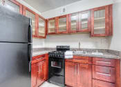 Thumbnail 1 of 24 - a kitchen with wood cabinets and a black stove and refrigerator