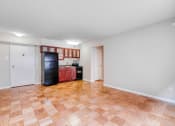 Thumbnail 8 of 24 - a kitchen with a black refrigerator and wooden floors