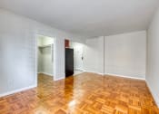 Thumbnail 6 of 24 - an empty living room with wood flooring and white walls