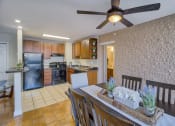 Thumbnail 1 of 50 - a dining room and kitchen with a table and a ceiling fan